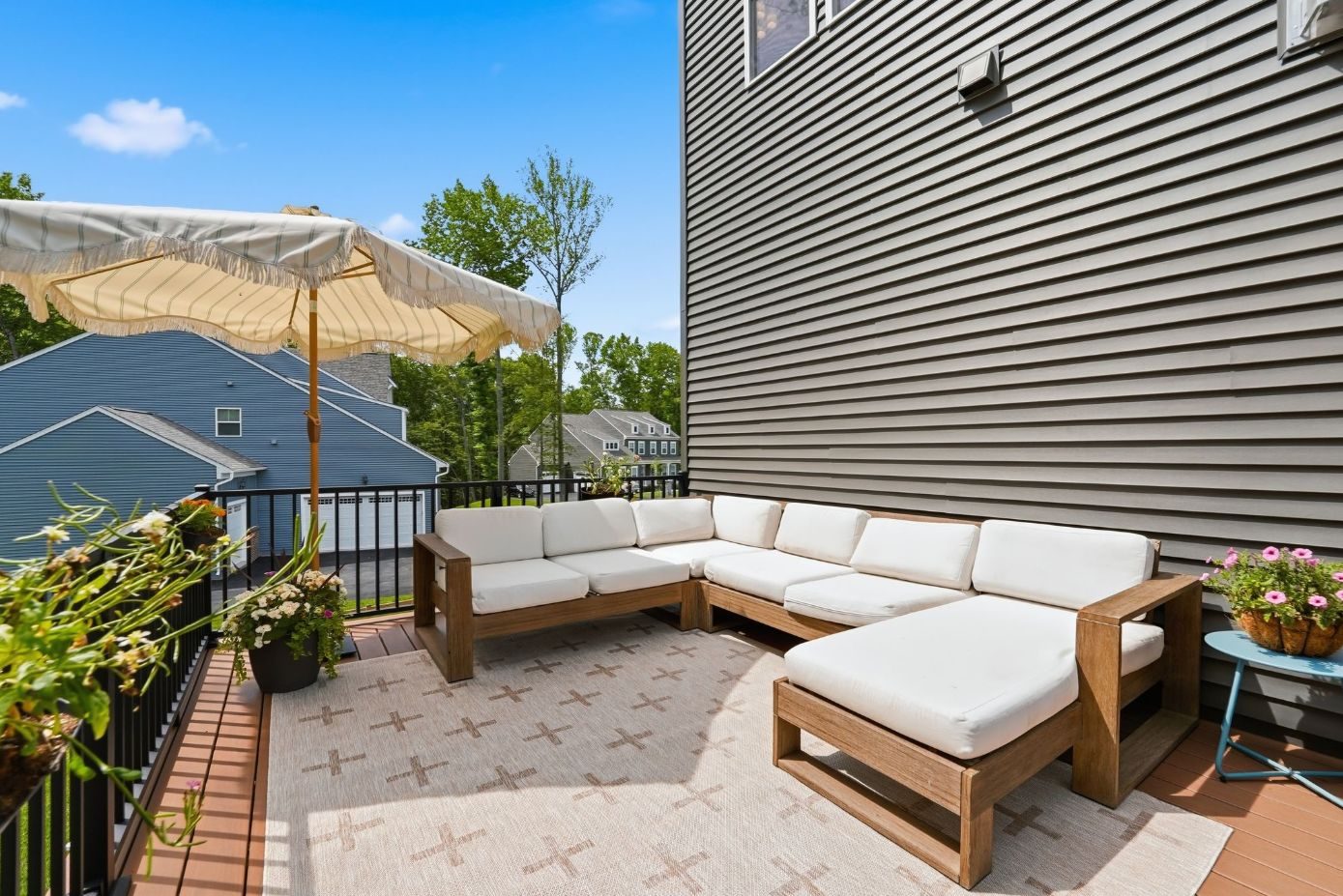 Second-story deck furnished with a sectional and umbrella